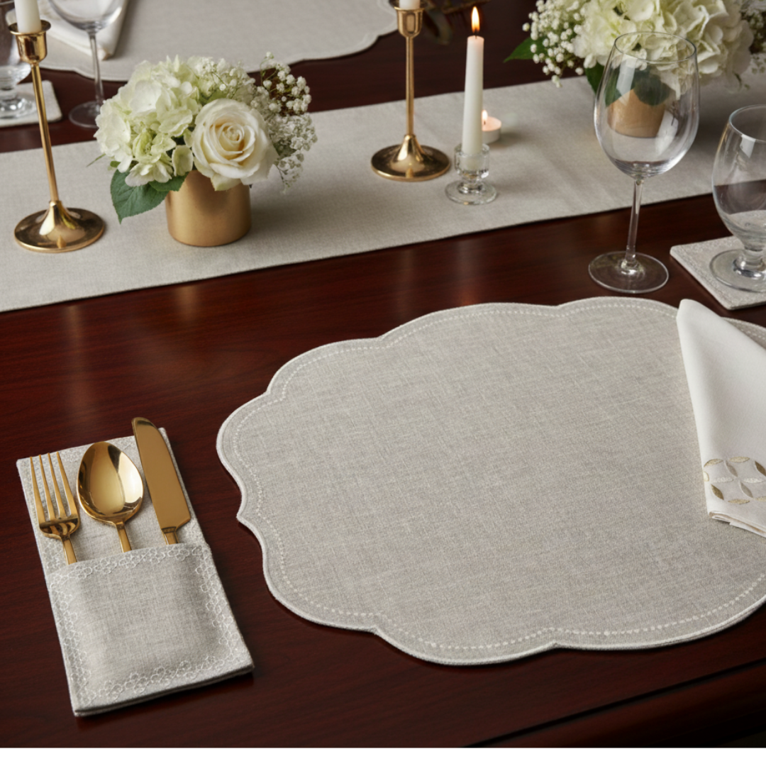 Table setting with a decorative placemat, cutlery, and floral arrangements.