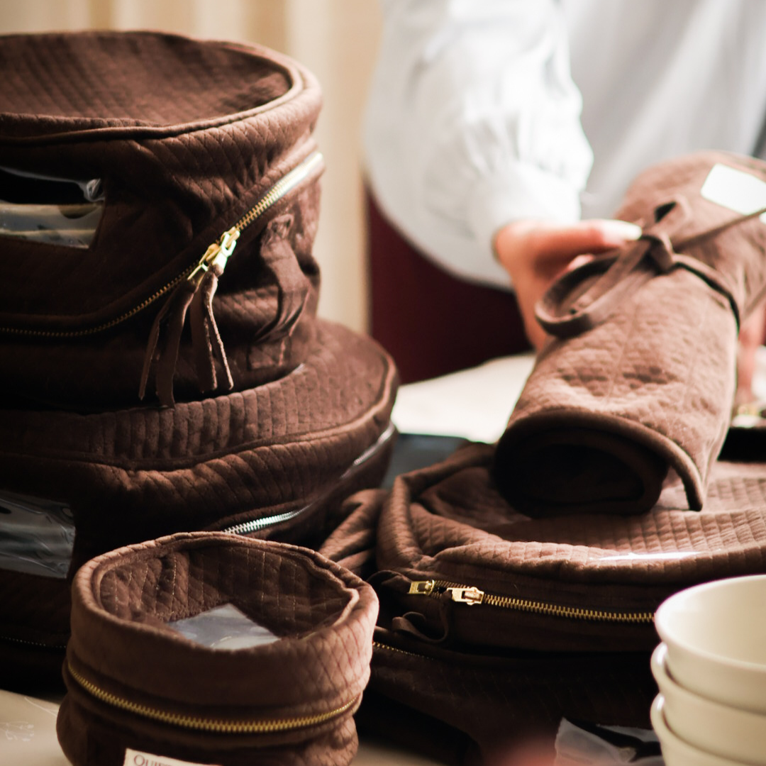 Brown quilted bags with zippers on a table