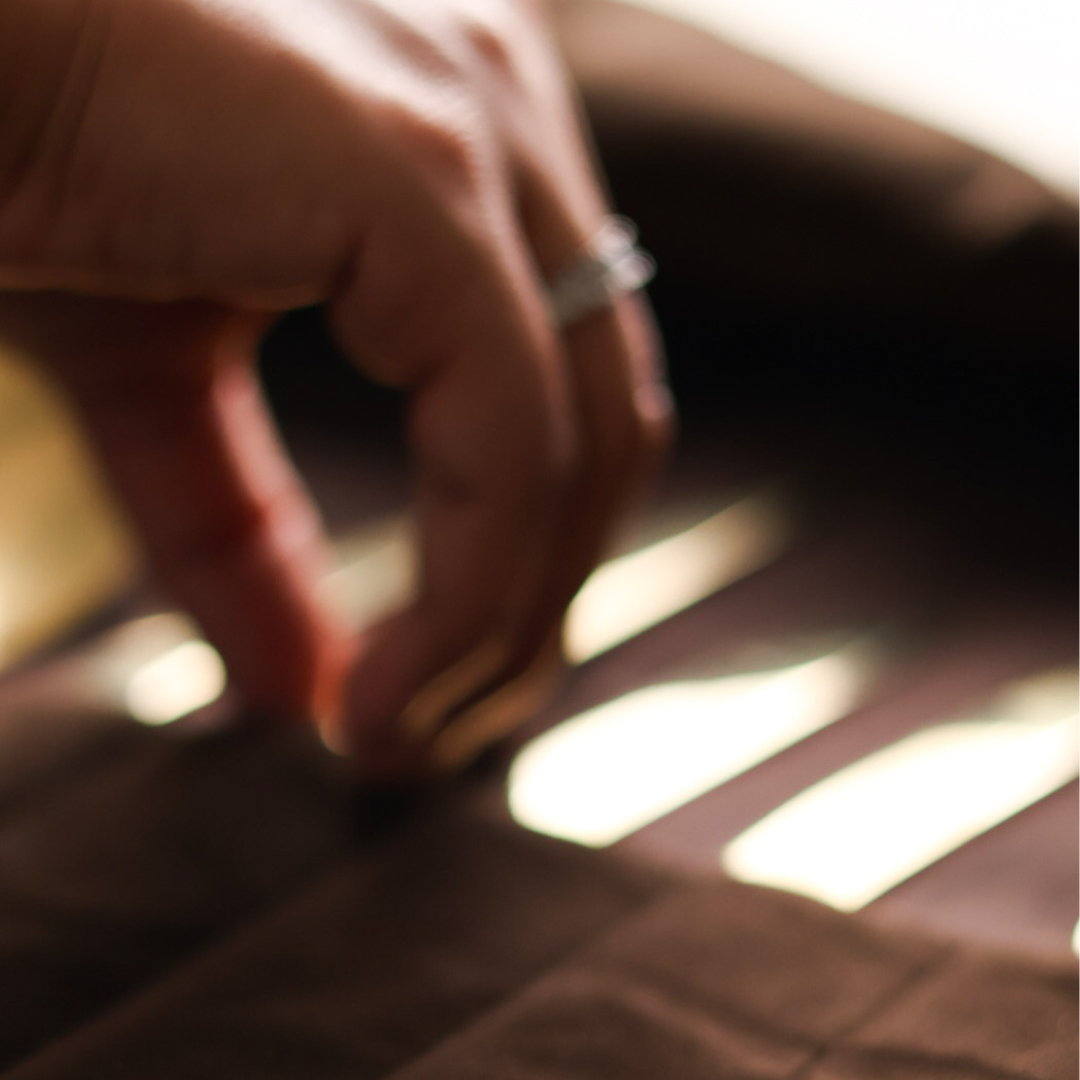 Close-up of a hand with a ring on a wooden surface
