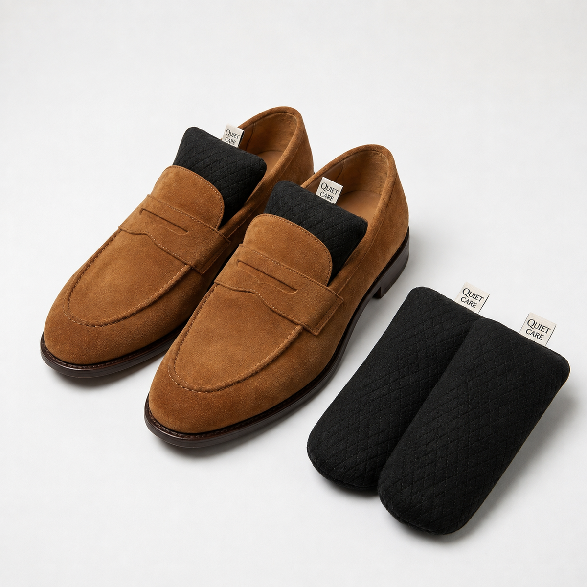 Full length quilted velvet shoe shapers in black shown beside loafers