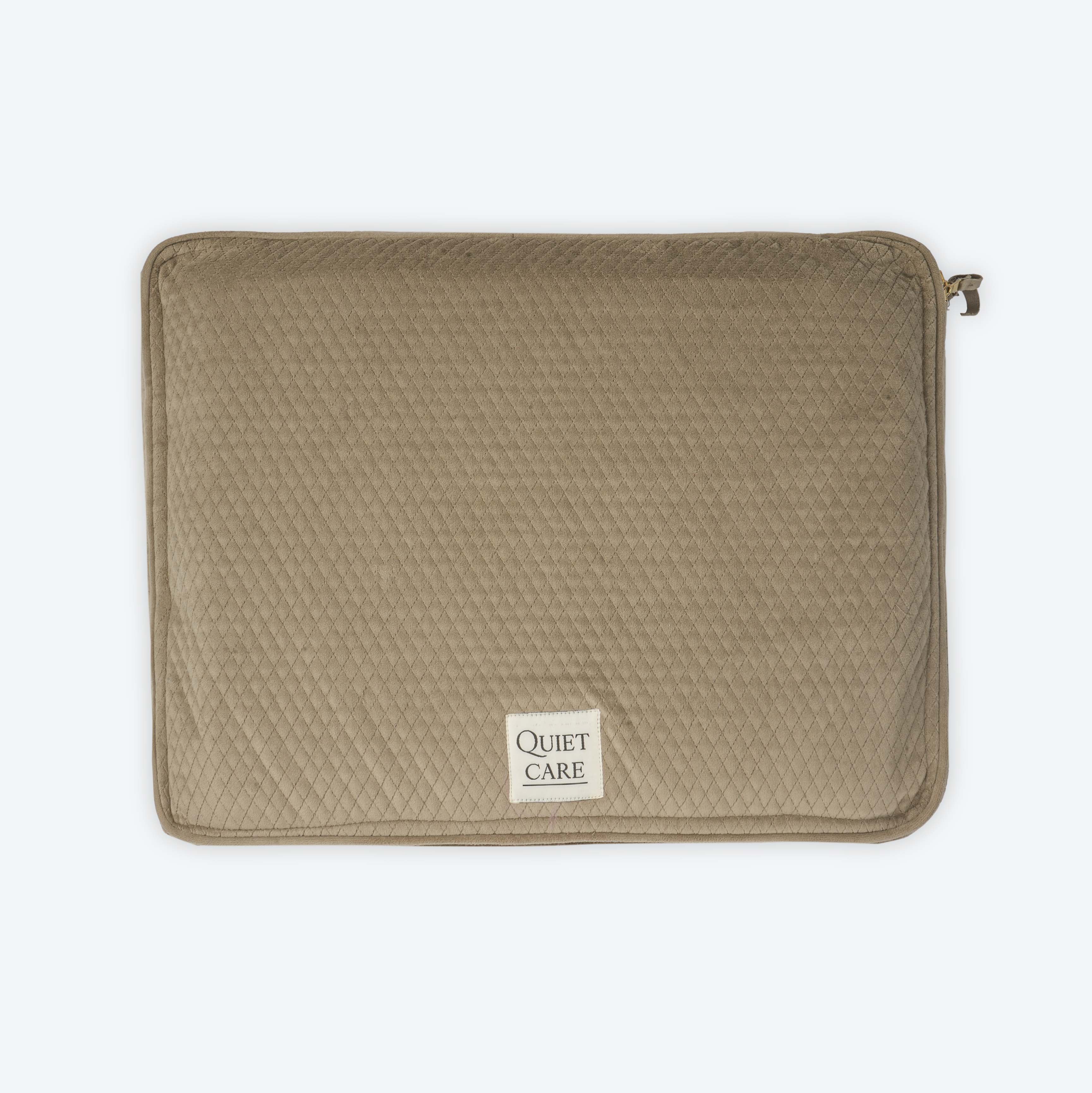 Brown quilted pouch with 'Quiet Care' label on a white background