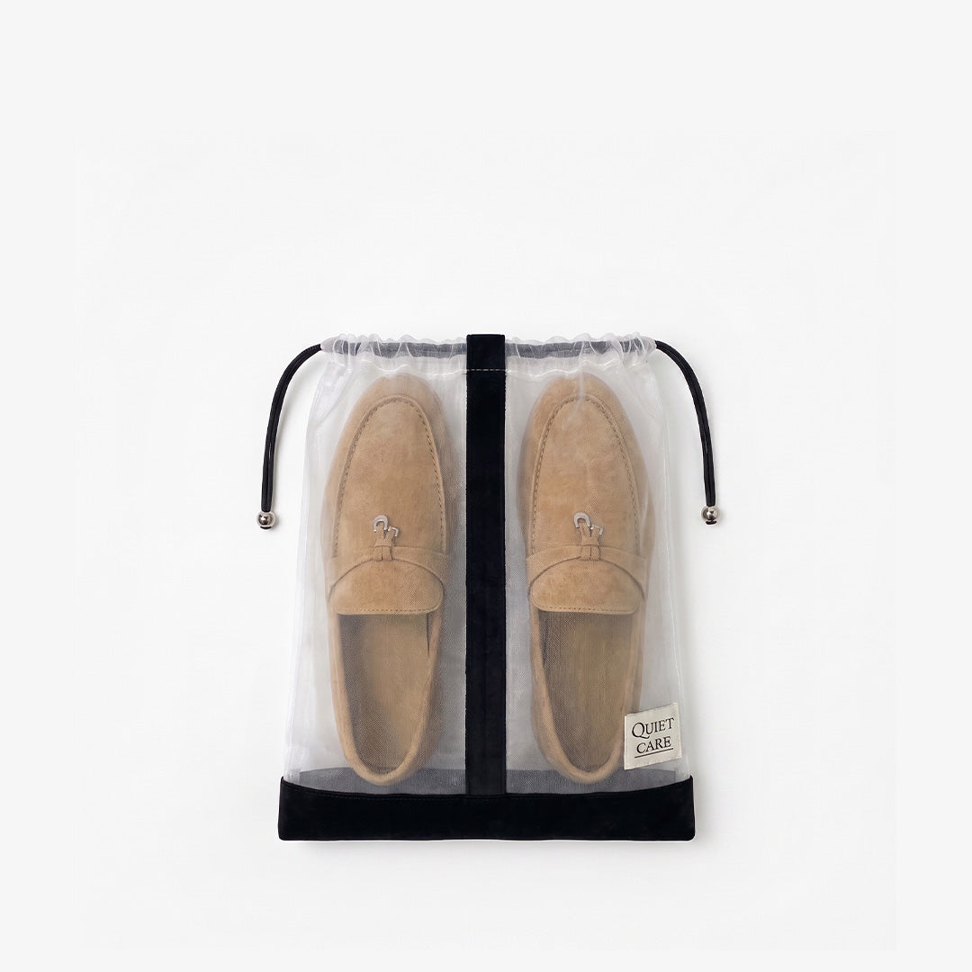 Sheer shoe bag with velvet trim holding a pair of loafers, each shoe kept apart