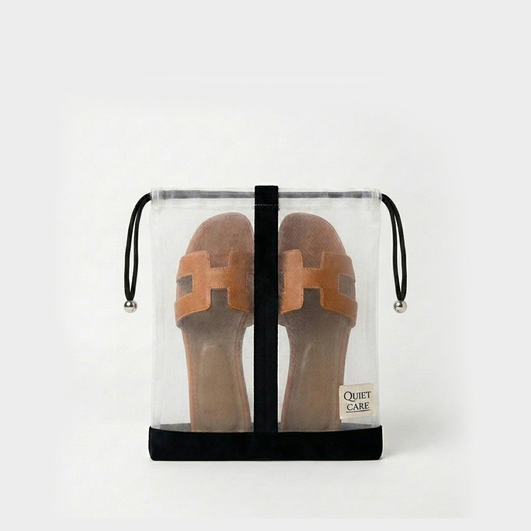 Sheer shoe bag with velvet trim holding a pair of shoes, centre divider visible