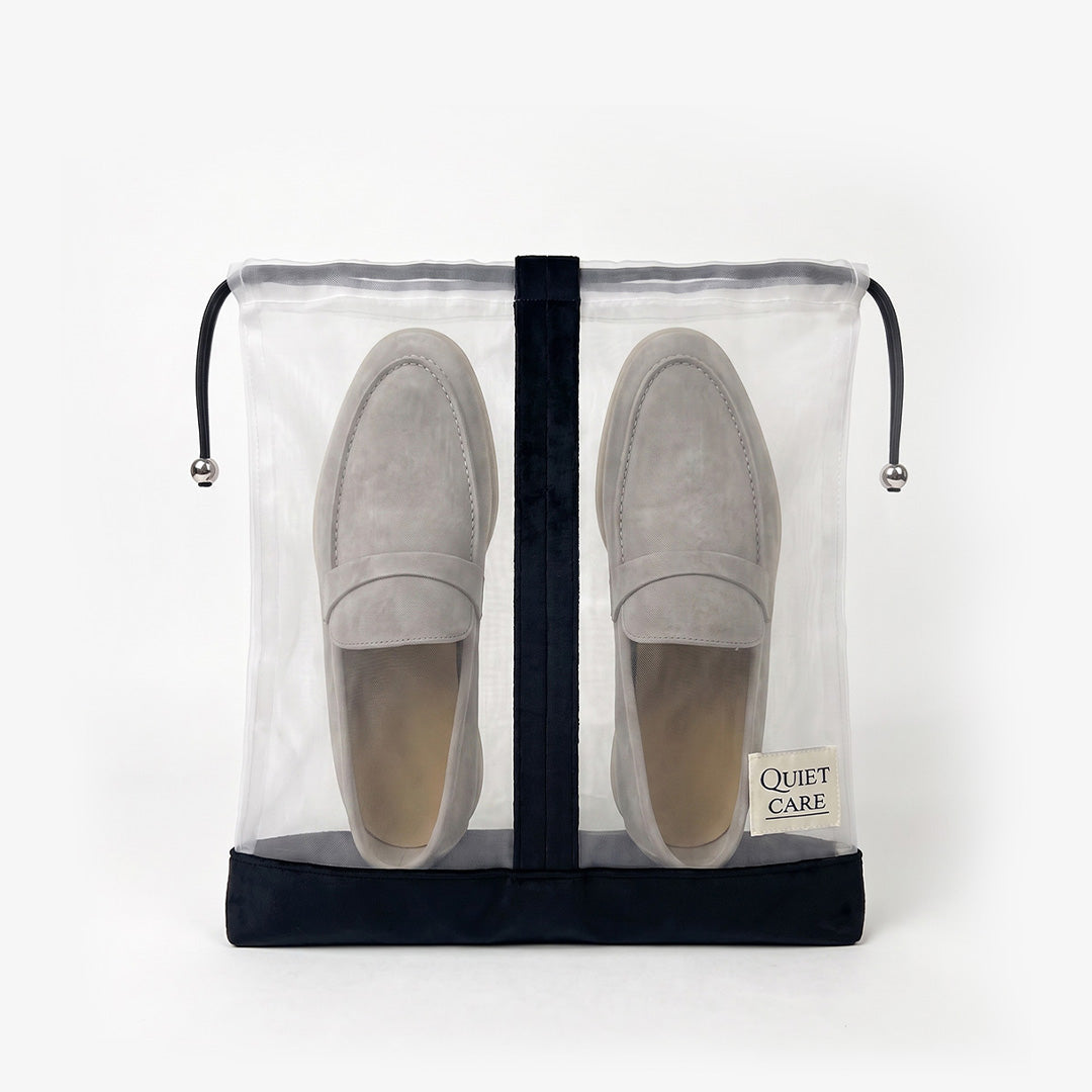 Sheer shoe bag with velvet trim holding a pair of shoes, centre divider visible